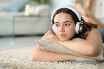 Pensive woman with headphone listening to music - 761245711