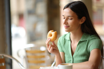 Woman eating doughnut in a terrace - 761245788