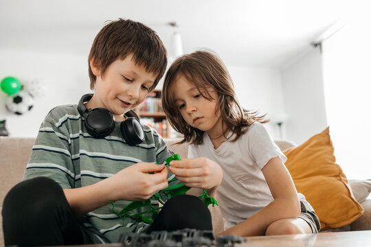 Boy teaching brother to make toy model at home