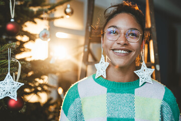 Smiling woman wearing star decoration in ears on Christmas