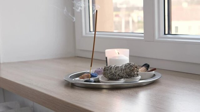 Aroma diffuser, burning candles on a metal tray on the windowsill. Concept of rituals, meditations at home