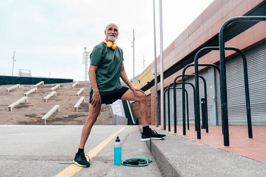 Retired senior man standing by parallel bars