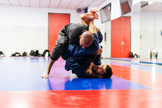 Athletes practicing jiu-jitsu at dojo