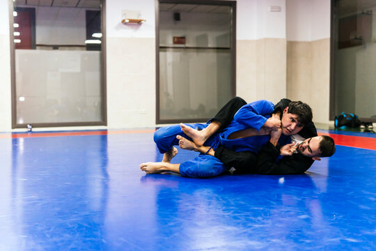 Athletes doing wrestling in jujitsu training at dojo