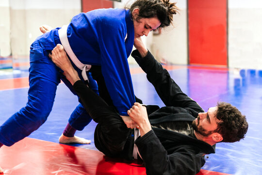 Athletes dueling in jujitsu training at dojo