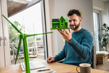 Architect examining model house at desk