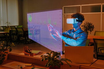 Businessman interacting with graphical interface using virtual reality simulator in office