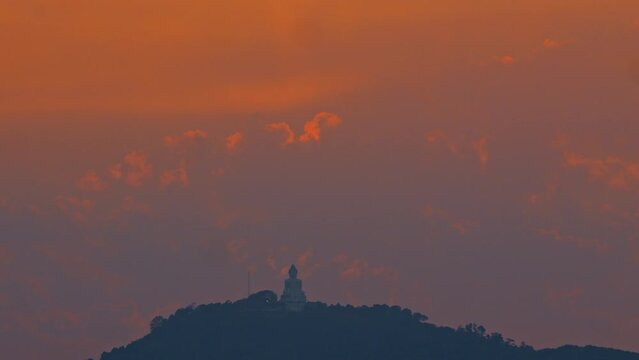 Phuket big Buddha on a hilltop at sunset Phuket Big Buddha is a symbol of peace and serenity. It's located on a hilltop overlooking the city and is a popular tourist attraction. bright sky background