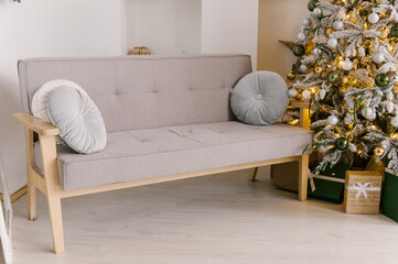Beautiful minimalistic interior, sofa with Christmas tree