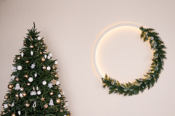 Stylish Christmas wreath with backlight on a white wall background, New Year decor, empty space for text