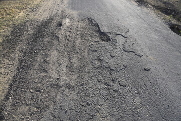 Bad road with damaged and broken asphalt