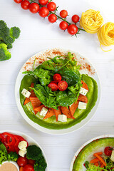 Salad of pumpkin, spinach, feta cheese and cherry tomatoes. Topped with sauce. Keto diet.