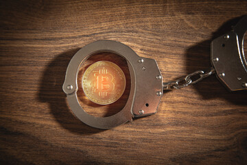 Golden bitcoin and handcuffs. Virtual currency