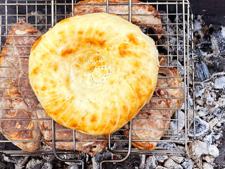 Outdoor barbecue. Meat and pita bread on a grill over hot coals