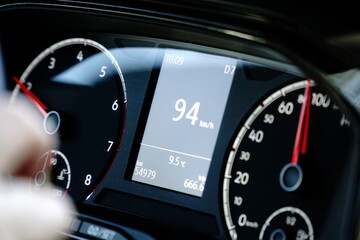 Speedometer and hands on a steering wheel - driving at 94 kmh