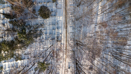Drone photography of a large cemetery in a forest covered by snow during winter day