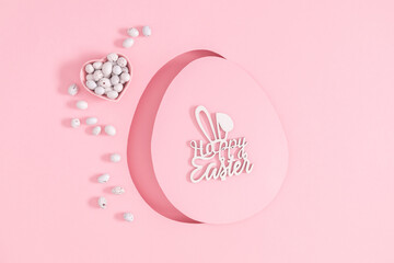 Happy Easter composition. Easter chocolate eggs and chocolate candies on pastel pink background. Top view. Flat lay.