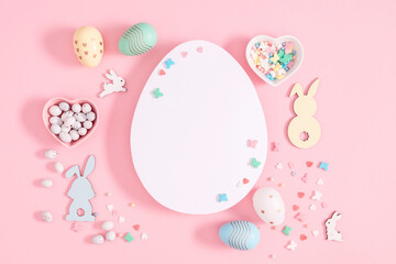 Easter holiday composition. Easter eggs, decorations, bunny, flowers, isolated on pastel pink background. Easter concept. Flat lay, top view, copy space