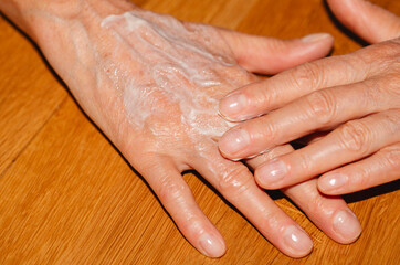 Details of woman applying hand cream.