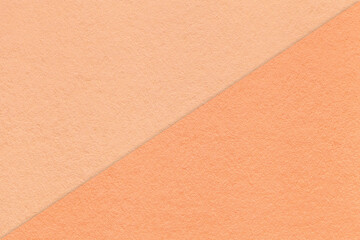Texture of craft peach fuzz and coral paper background, half two colors, macro. Vintage kraft...