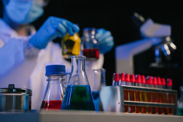 Team of biochemical research scientists working with a microscope for vaccine development in pharmaceutical research labeling.