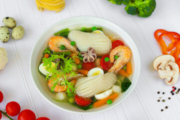 Seafood soup with squid, shrimp and boiled egg. Diet food.