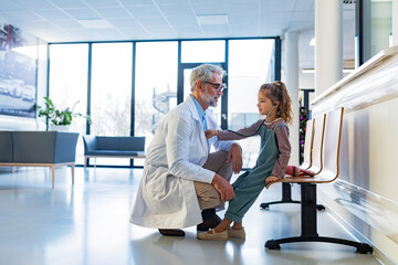 Little girl listening to the doctor's heart with stethoscope. Role reversal. Friendly relationship...