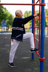 Fototapeta premium Sports grandfather doing fitness outdoors in park