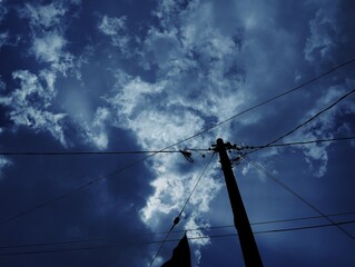 Silhouette of electric pole under the sky