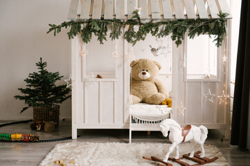 Beautiful stylish modern interior of a children's room with a wooden bed and a toy decorated for the new year