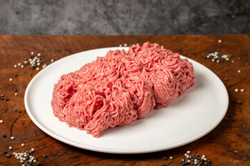 Ground beef. Butcher products. Fresh minced meat on dark background. Close up