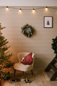 Beautiful New Year decor in a stylish interior with a Christmas tree, wreath and gifts