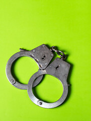 Handcuffs on the Green Background - 761298368