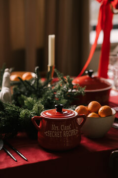 Beautiful New Year decor, a Christmas table with a red tablecloth and candles, festive dishes and glasses