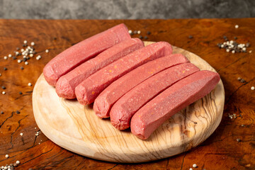 Raw sausage. Butcher products. Sausages made from uncooked beef on a dark background. Close up