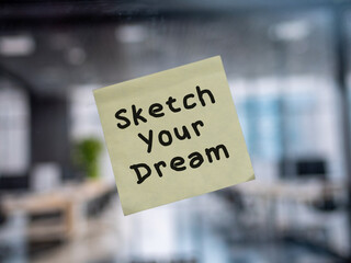 Post note on glass with 'Sketch Your Dream'.