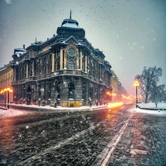 Poster Snow blowing in front of an old building in Bucharest during the winter. © Veres