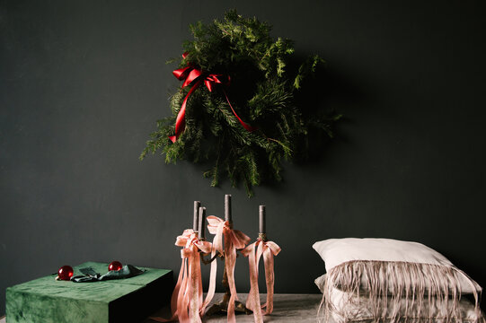 Beautiful New Year decor, a Christmas wreath on a vintage chest of drawers in a stylish dark living room interior