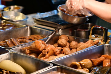 Close-up of a braised food stall in Nanjichang Night Market (a historic night market with affordable and diverse food options), showing braised chicken legs and meatballs.