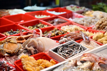 In Nanjichang Night Market, Taipei, a stir-fry stall offers a variety of affordable and delicious seafood. This close-up shot highlights the juicy squid, alongside other fresh fish options.