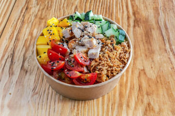 Takeaway vegan poke bowl with tofu, mango and vegetables in recycled kraft paper packaging. Healthy Trendy
