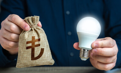 Turkish lira money bag and burning idea light bulb in the hands of a man. Reduce carbon footprint....
