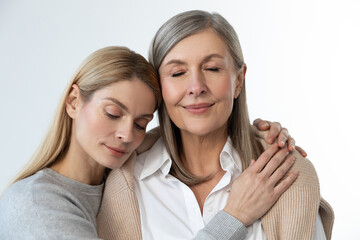 Two women standing close and looking peaceful and relaxed