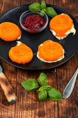 Baked camembert on rustic wooden table.