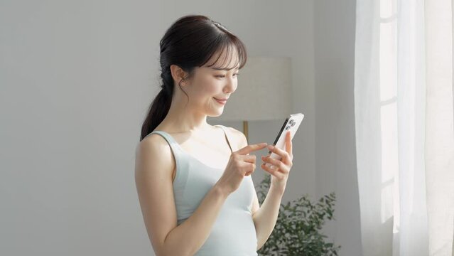 自宅で携帯を触る日本人女性