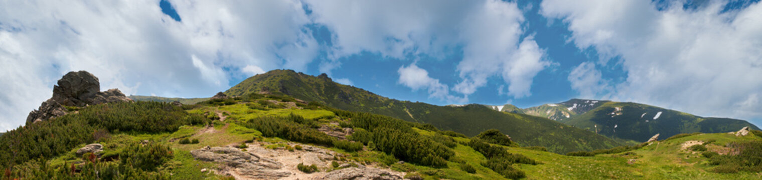 Summer mountain view with snow and big stones on mountainside. Five shots stitch image.