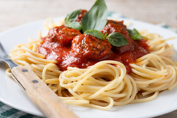 Spaghetti with meatballs on wooden table. Close up