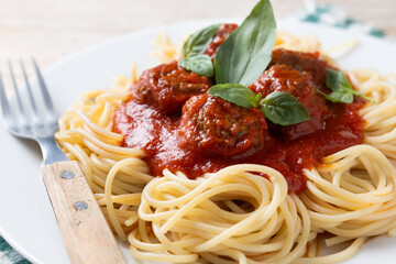 Spaghetti with meatballs on wooden table. Close up