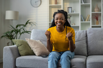 Young woman watching tv and looking excited