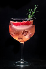 Cocktail with fresh fruit. Gin and tonic drink with ice at a party, on a black background. Alcohol with pink graperfuit and rosemary - 761333924